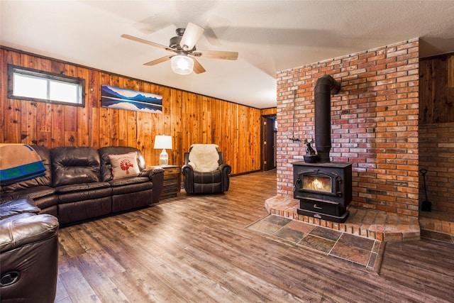 630 Tally Lake Rd, Whitefish, MT 59937 - living area with a wood stove, a ceiling fan, wood walls, and wood finished floors