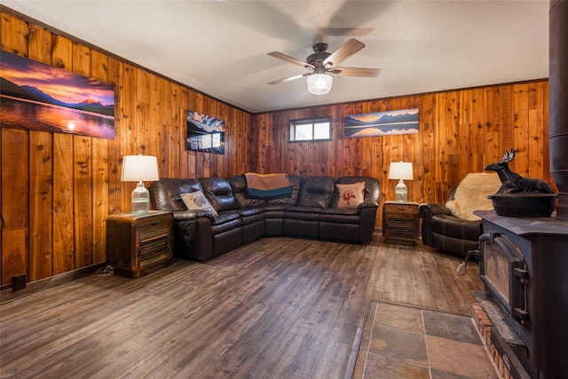 630 Tally Lake Rd, Whitefish, MT 59937 - living room with a wood stove, ceiling fan, wood walls, and dark wood-style floors