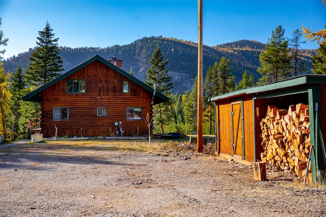 630 Tally Lake Rd, Whitefish, MT 59937 - view of property exterior featuring a mountain view, a chimney, and log exterior