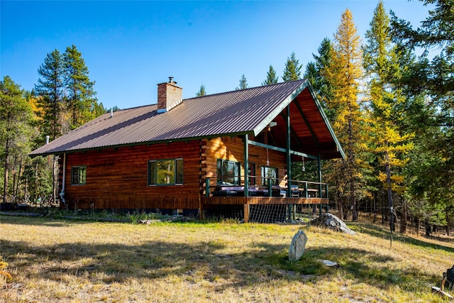 630 Tally Lake Rd, Whitefish, MT 59937 - rear view of property featuring a chimney, log exterior, a lawn, and a metal roof
