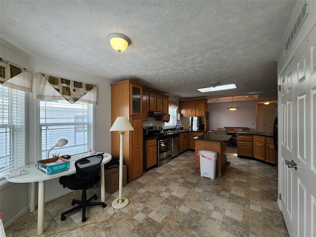 1208 8th Ave NW, Great Falls, MT 59404 - kitchen with stainless steel appliances, dark countertops, brown cabinetry, glass insert cabinets, and a center island