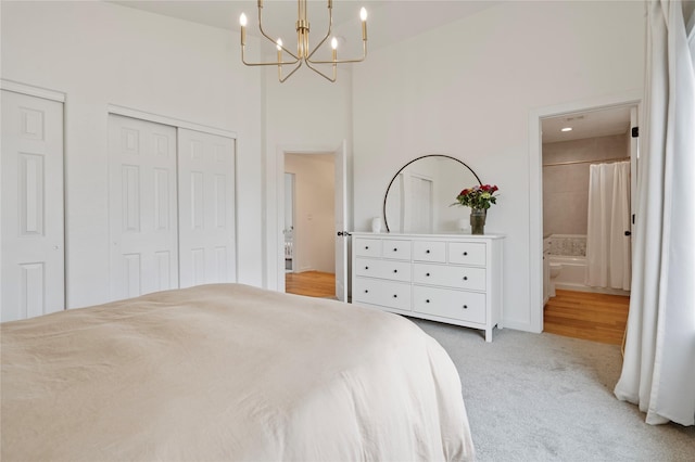 301 Buttercup Loop, Kalispell, MT 59901 - bedroom featuring a chandelier, light carpet, a high ceiling, ensuite bathroom, and two closets