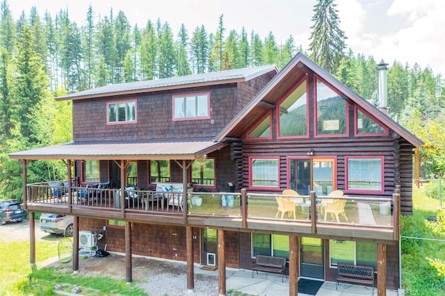 2755 US Highway 93 W, Whitefish, MT 59937 - view of front of property with log siding, a metal roof, and a view of trees