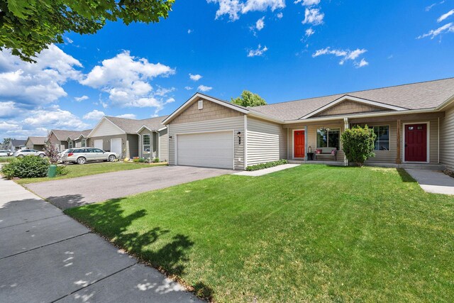 64 Empire Loop, Kalispell, MT 59901 - ranch-style house with asphalt driveway, an attached garage, a front lawn, covered porch, and a shingled roof