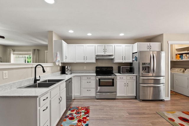 64 Empire Loop, Kalispell, MT 59901 - kitchen with stainless steel appliances, separate washer and dryer, white cabinetry, light wood-type flooring, and recessed lighting