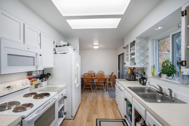 609 11th Ave E, Polson, MT 59860 - kitchen featuring white appliances, light countertops, white cabinets, light wood finished floors, and glass insert cabinets