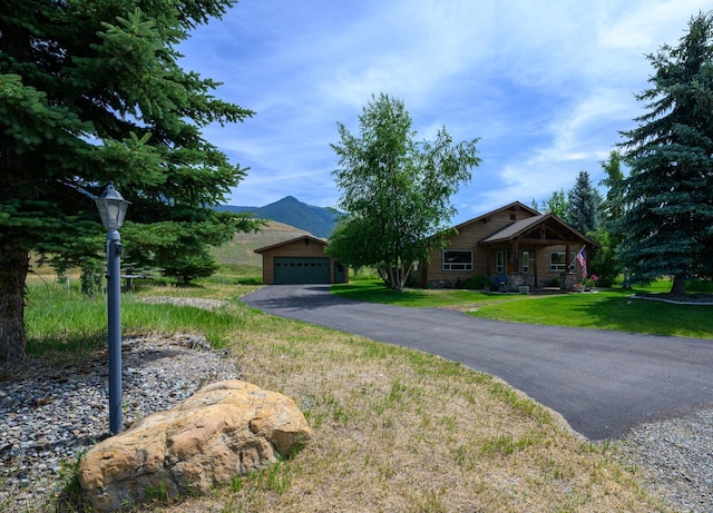 192 Leonard Ln, Eureka, MT 59917 - view of front facade featuring a mountain view, a front yard, a garage, and a porch
