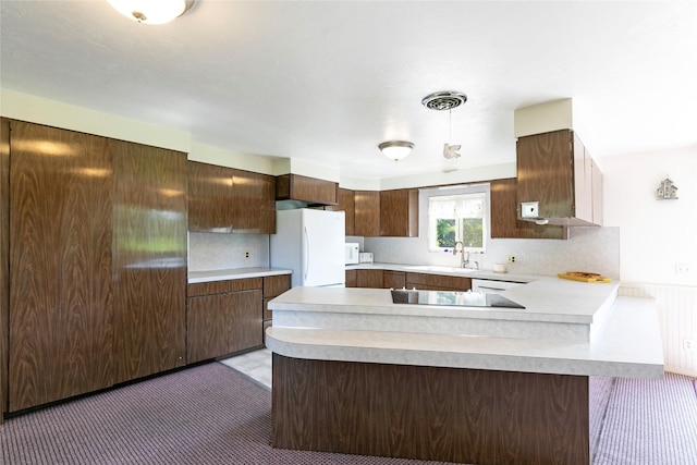 232 Kurtz Ln, Hamilton, MT 59840 - kitchen with white appliances, light countertops, a peninsula, dark brown cabinets, and decorative backsplash