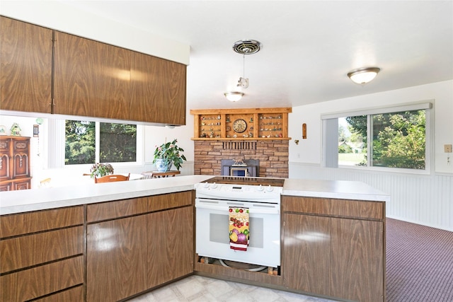 232 Kurtz Ln, Hamilton, MT 59840 - kitchen with white electric stove, light countertops, a peninsula, and a wainscoted wall