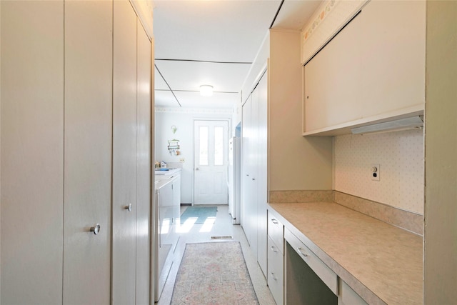 232 Kurtz Ln, Hamilton, MT 59840 - kitchen featuring washing machine and dryer, light countertops, freestanding refrigerator, and cream cabinetry