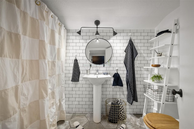438 Somers Ave, Whitefish, MT 59937 - bathroom with tile patterned flooring, tile walls, and a shower with shower curtain