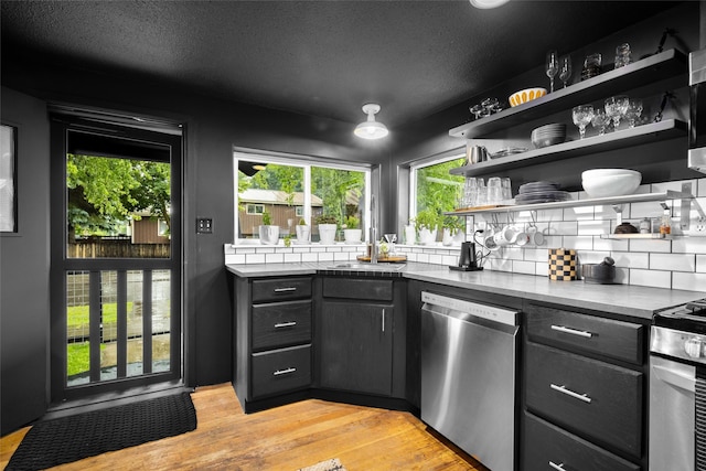 438 Somers Ave, Whitefish, MT 59937 - kitchen featuring appliances with stainless steel finishes, open shelves, backsplash, light wood finished floors, and a textured ceiling