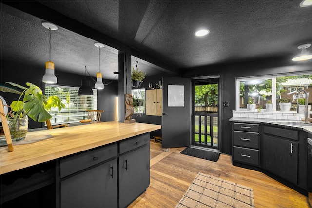 438 Somers Ave, Whitefish, MT 59937 - kitchen featuring butcher block countertops, a textured ceiling, light wood-style floors, hanging light fixtures, and recessed lighting