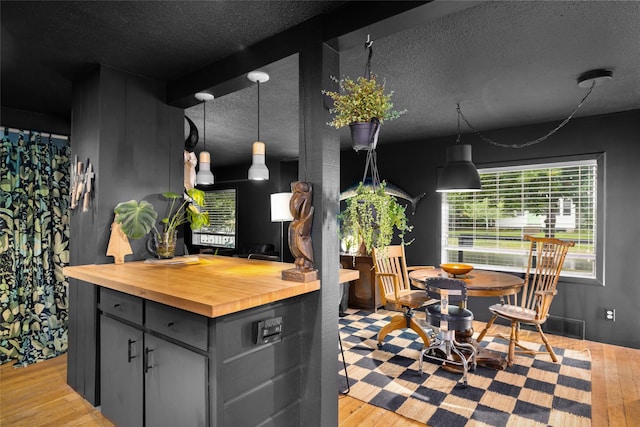 438 Somers Ave, Whitefish, MT 59937 - kitchen featuring wood counters, light wood finished floors, a textured ceiling, gray cabinets, and decorative light fixtures
