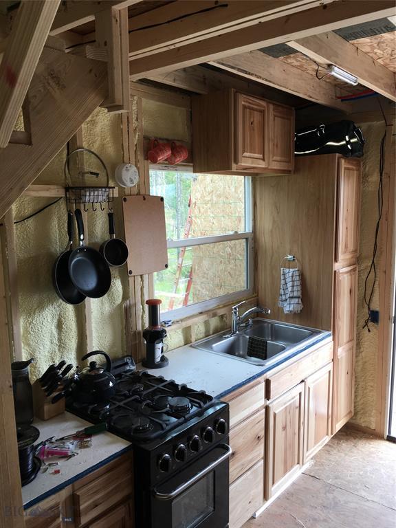 210 Grouse Hill Dr, Anaconda, MT 59711 - kitchen featuring gas stove, light countertops, and brown cabinetry