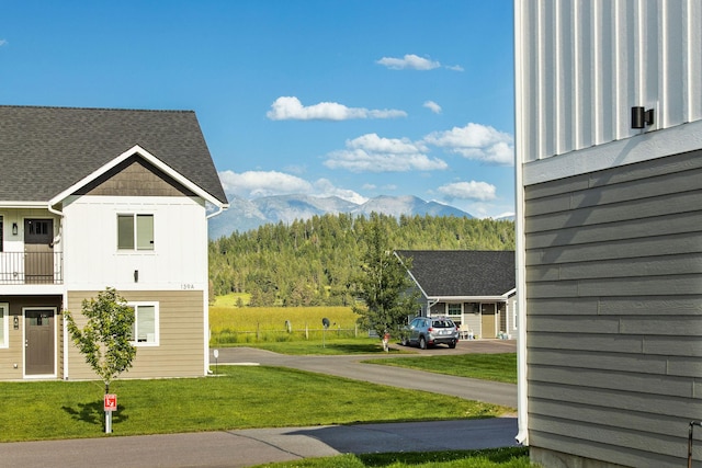 138 Jewel Basin Ct, Bigfork, MT 59911 - view of side of home with board and batten siding, a yard, a mountain view, and a forest view