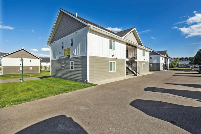 138 Jewel Basin Ct, Bigfork, MT 59911 - view of side of property featuring board and batten siding, stairs, a lawn, and a residential view