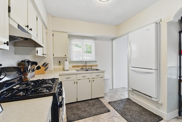 3120 1st Ave N, Great Falls, MT 59401 - kitchen with black range with gas stovetop, freestanding refrigerator, under cabinet range hood, light countertops, and white cabinetry