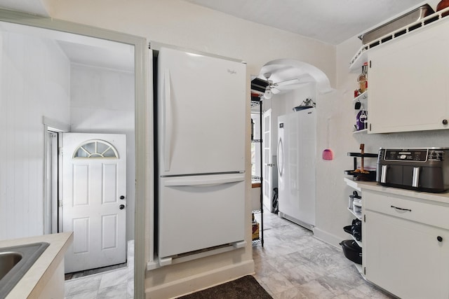 3120 1st Ave N, Great Falls, MT 59401 - kitchen featuring freestanding refrigerator, white cabinetry, light countertops, and light marble finish floors