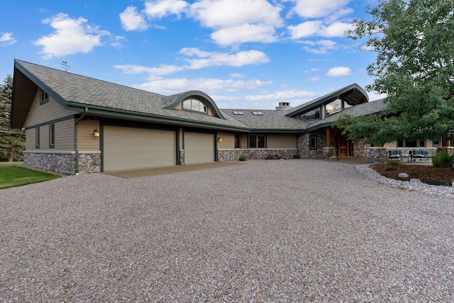 639 Three Eagle Ln, Bigfork, MT 59911 - view of front facade with stone siding, a garage, and driveway