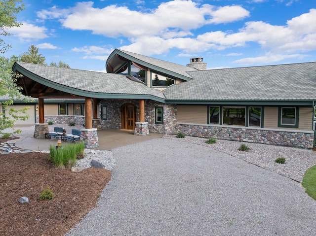 639 Three Eagle Ln, Bigfork, MT 59911 - view of front facade with stone siding and a chimney