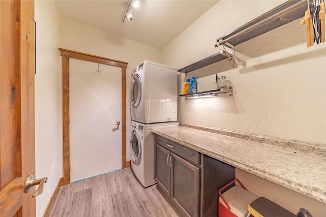 439 Osborn Ave Unit 115, Bigfork, MT 59911 - washroom with stacked washer / drying machine, light wood finished floors, and cabinet space