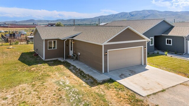 415 I St, Townsend, MT 59644 - ranch-style house with a garage, a mountain view, concrete driveway, and a front yard