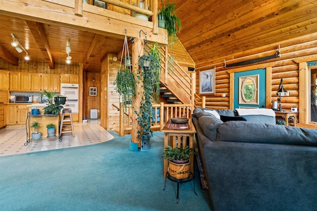 487 Hudson Ln, Victor, MT 59875 - living room featuring a wooden ceiling with exposed beams, light colored carpet, rustic walls, a towering ceiling, and wood walls