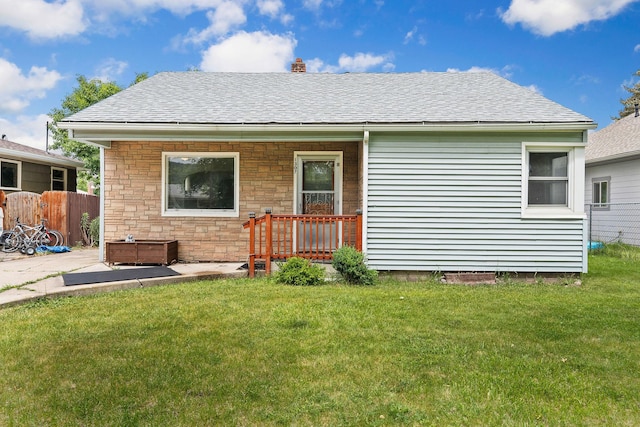 1307 4th St W, Kalispell, MT 59901 - back of property featuring roof with shingles, a chimney, a patio, and stone siding