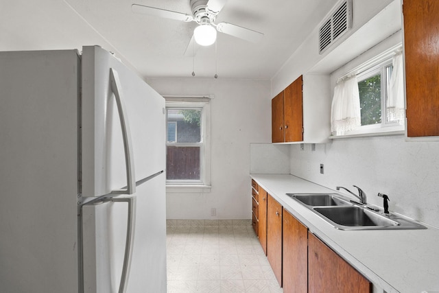 1307 4th St W, Kalispell, MT 59901 - kitchen with freestanding refrigerator, brown cabinets, light floors, light countertops, and ceiling fan