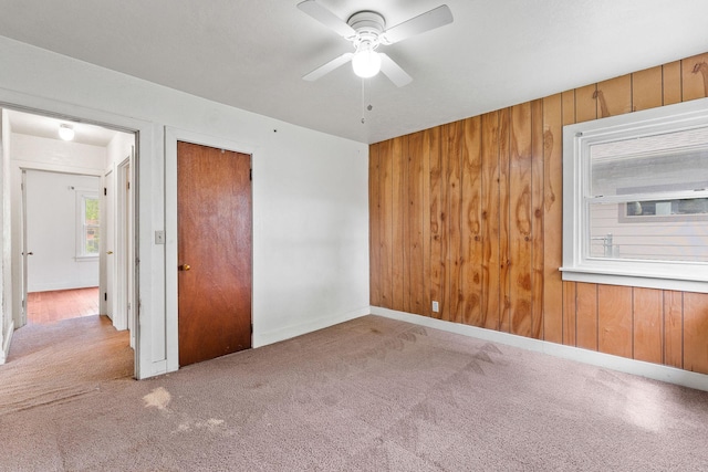 1307 4th St W, Kalispell, MT 59901 - unfurnished bedroom with carpet floors, wooden walls, a ceiling fan, and a closet