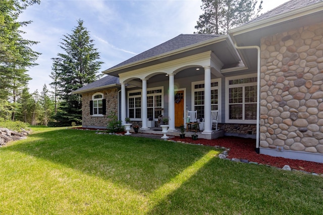 20245 Swan View Rd, Rollins, MT 59931 - view of front of home featuring a front lawn, stone siding, covered porch, and a shingled roof