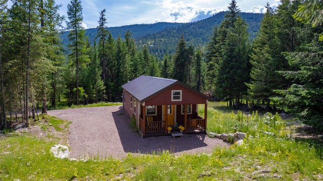20245 Swan View Rd, Rollins, MT 59931 - exterior space with a view of trees, covered porch, a mountain view, and gravel driveway