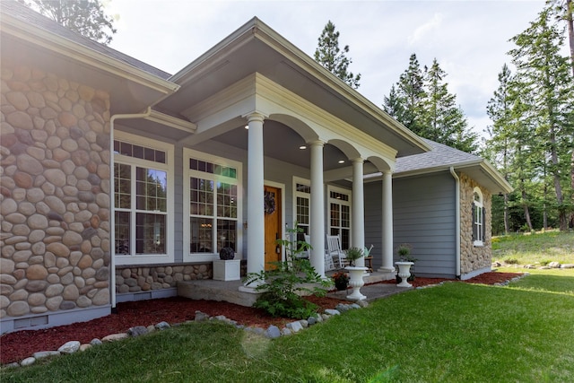 20245 Swan View Rd, Rollins, MT 59931 - doorway to property with stone siding, a porch, and a lawn