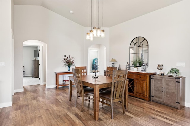 4460 Sunburst Ln, Stevensville, MT 59870 - dining space featuring arched walkways, high vaulted ceiling, and wood finished floors