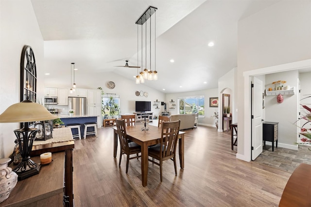 4460 Sunburst Ln, Stevensville, MT 59870 - dining area featuring a ceiling fan, high vaulted ceiling, wood finished floors, and arched walkways