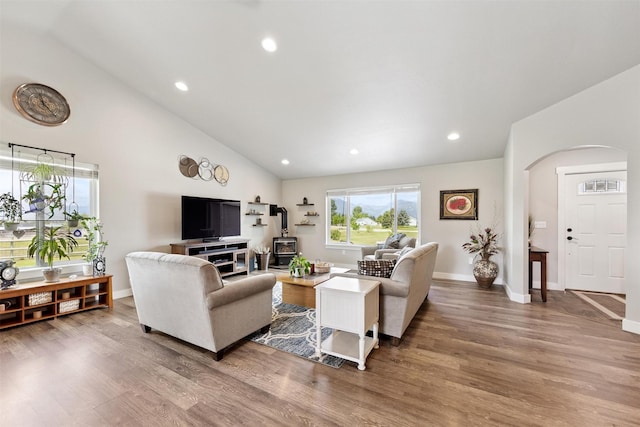 4460 Sunburst Ln, Stevensville, MT 59870 - living area with arched walkways, wood finished floors, recessed lighting, a wood stove, and high vaulted ceiling