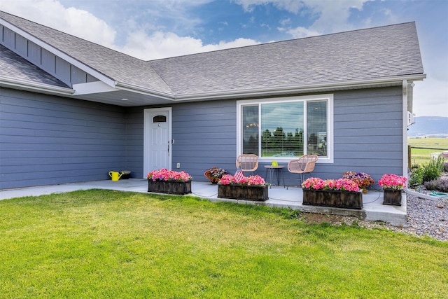 4460 Sunburst Ln, Stevensville, MT 59870 - view of exterior entry featuring a lawn and a shingled roof