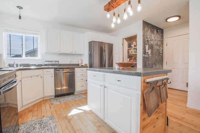 205 Kolczak Ln, Townsend, MT 59644 - kitchen featuring stainless steel appliances, light wood-type flooring, dark countertops, and white cabinets