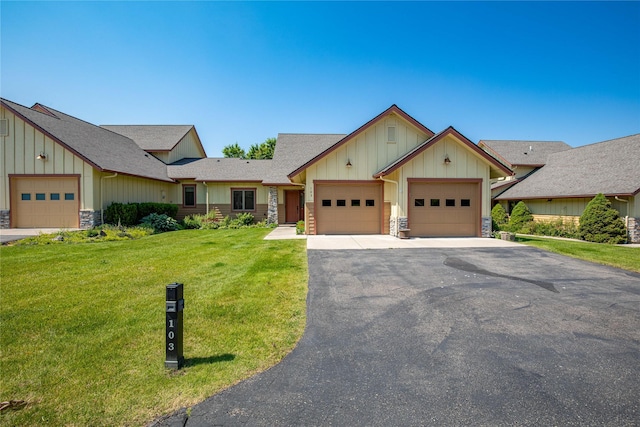 103 Crescent Lndg, Polson, MT 59860 - craftsman-style house with board and batten siding, stone siding, a front lawn, and a garage