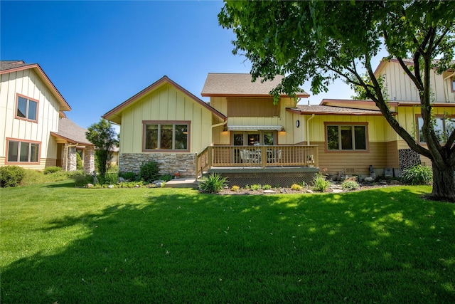 103 Crescent Lndg, Polson, MT 59860 - rear view of property with board and batten siding, a lawn, stone siding, and a wooden deck
