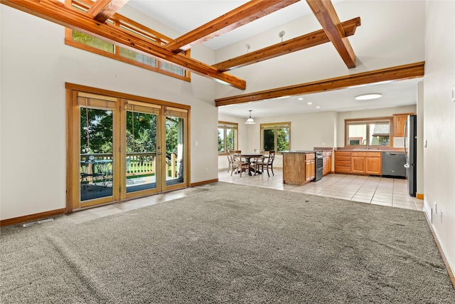 103 Crescent Lndg, Polson, MT 59860 - living area featuring light tile patterned floors, light carpet, beamed ceiling, and a high ceiling
