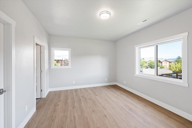 NHN Shiloh Ave Unit 1-16, Whitefish, MT 59937 - unfurnished bedroom featuring multiple windows and light wood-type flooring