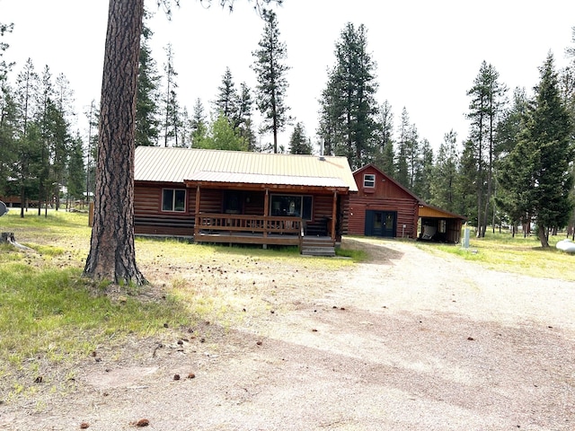 645 Morrell Creek Dr, Seeley Lake, MT 59868 - log home featuring driveway, covered porch, a metal roof, and log exterior