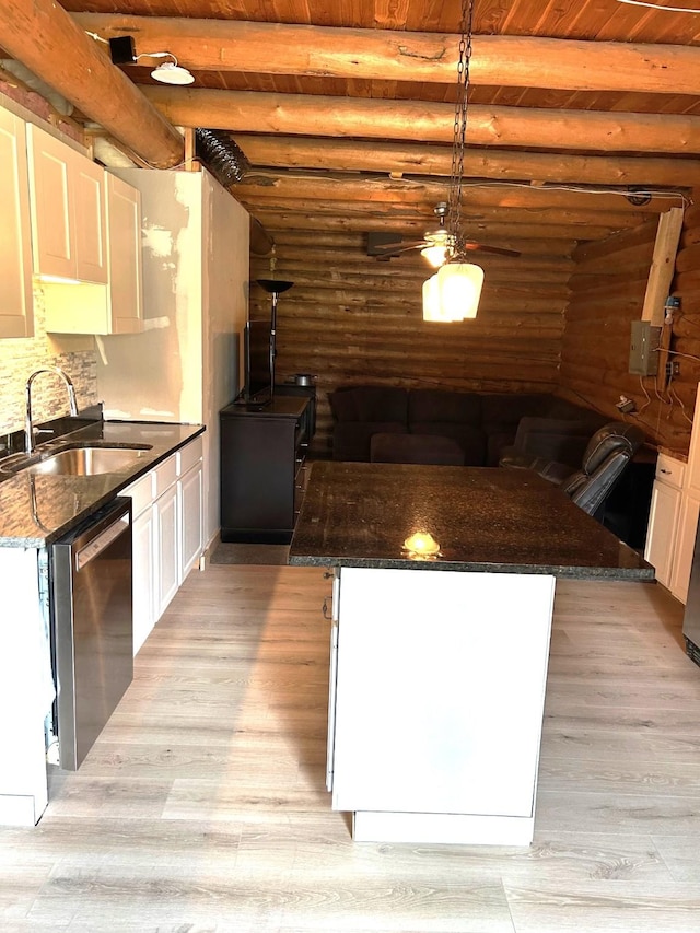 645 Morrell Creek Dr, Seeley Lake, MT 59868 - kitchen featuring stainless steel dishwasher, log walls, light wood finished floors, white cabinetry, and a wooden ceiling with exposed beams