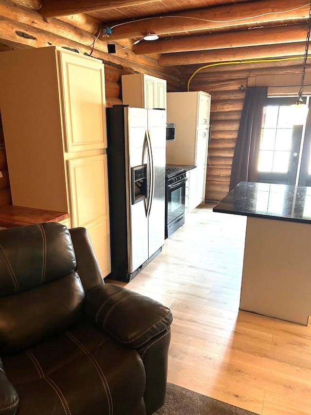645 Morrell Creek Dr, Seeley Lake, MT 59868 - kitchen with stainless steel refrigerator with ice dispenser, rustic walls, black range with gas stovetop, light wood-style floors, and dark stone countertops