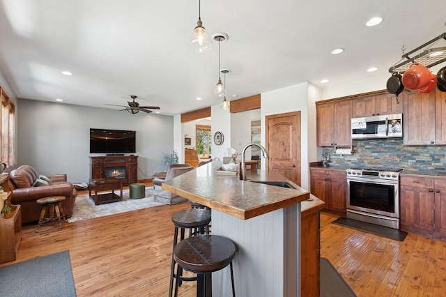 101 Heavens Peak Dr, Kalispell, MT 59901 - kitchen with stainless steel appliances, open floor plan, light wood-style floors, a breakfast bar, and recessed lighting