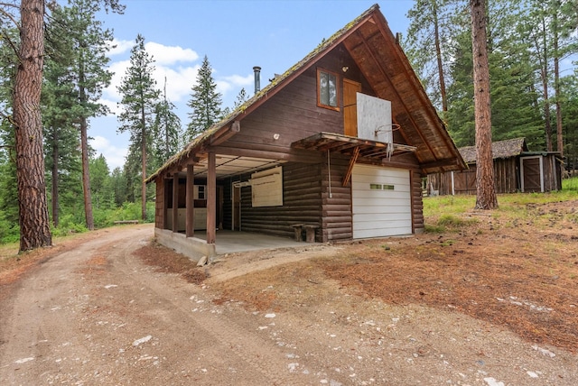 581 Timber Trl, Stevensville, MT 59870 - view of front of home with an outbuilding, dirt driveway, and a detached garage