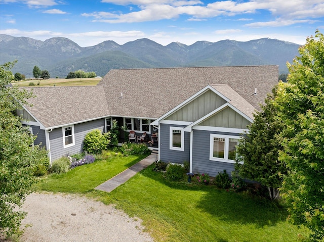 451 Creston Hatchery Rd, Kalispell, MT 59901 - view of front facade with board and batten siding, a shingled roof, a mountain view, and a front lawn