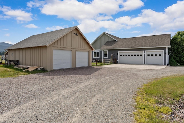 451 Creston Hatchery Rd, Kalispell, MT 59901 - view of front facade with board and batten siding, a detached garage, an outdoor structure, and roof with shingles